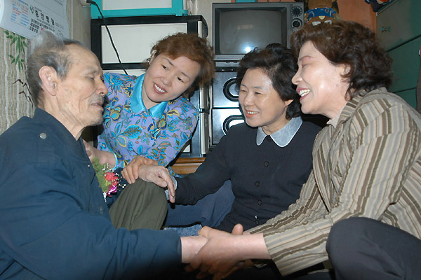 홀로 사시는 할아버지에게 카네이션을 달아드린 남구여성단체협의회 회원들(사진제공. 남구청)