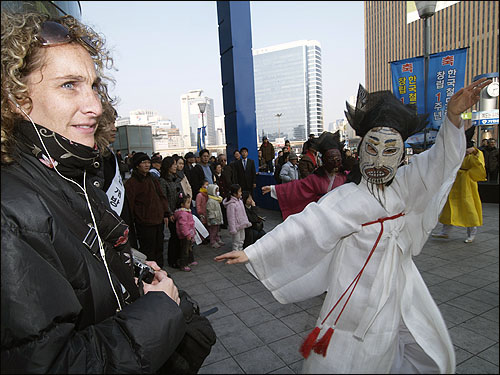 한국의 전통춤인 '양반춤'을 서울역을 지난던 외국인도 흥미롭게 지켜보고 있다.