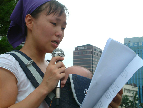5개월된 딸은 안은 이명희씨...건설노조 파업으로 구속된 남편의 석방을 호소하는 편지를 눈물로 읽고 있다.