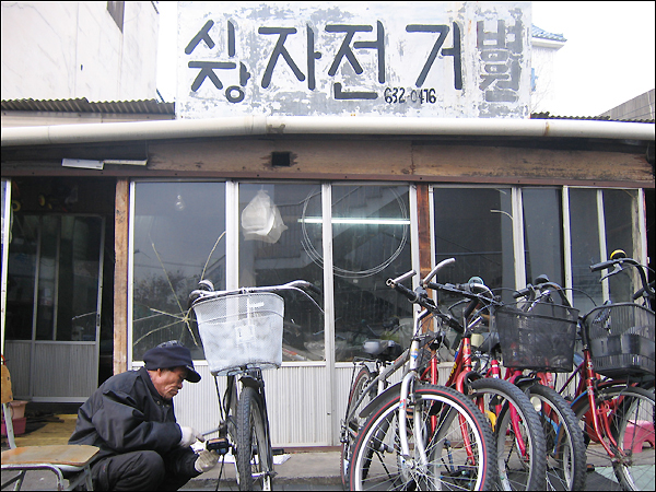 화원시장 '자전거병원장'으로 불리는 김태양(66)씨...자신이 직접 쓴 간판으로 38년째 꾸려가고 있다.