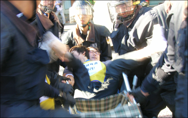 지난 10월 24일, 대구시교육청 앞에서 장애인교육권 확보를 주장하며 농성 중이던 한 여성을 경찰이 연행하고 있다(사진제공.대구장애인교육권연대)