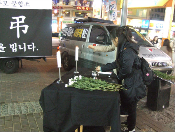 서울 용산 철거현장 참사로 목숨을 잃은 희생자들을 위해 분향하고 있는 시민(2009.1.21 대구 한일극장 앞 / 사진.남승렬 기자)