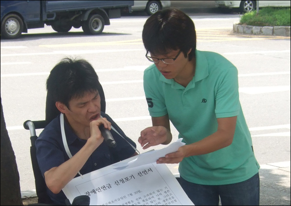 '장애인연금 포기.반납 선언문'을 읽고 있는 하형석씨와 대구장애인차별철폐연대 조민제 사무국장 / 사진. 평화뉴스 박광일 인턴기자