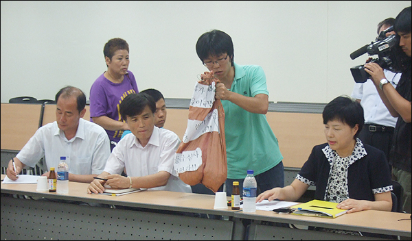 7월 30일 처음 지급된 '장애인연금' 9만원을 동전으로 바꿔 국민연금공단 김은경 대구지사장에게 전달하고 있다 / 사진. 평화뉴스 박광일 인턴기자