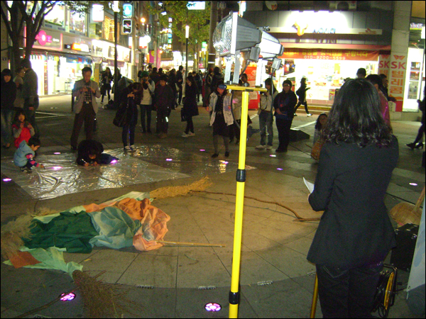 퍼포먼스를 지켜보는 시민들...대구 민예총은 매주 목요일 저녁 6시 30분에 중앙파출소 앞 광장에서 노래와 연극을 비롯한 다양한 형식으로 '4대강 사업 반대 목요 저항의 예술행동'을 이어가고 있다 / 사진. 평화뉴스 박광일 기자