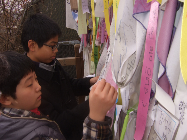 중학생들이 가로막힌 '자유의 다리' 벽에 리본을 달고 있다 / 사진. 평화뉴스 박광일 기자
