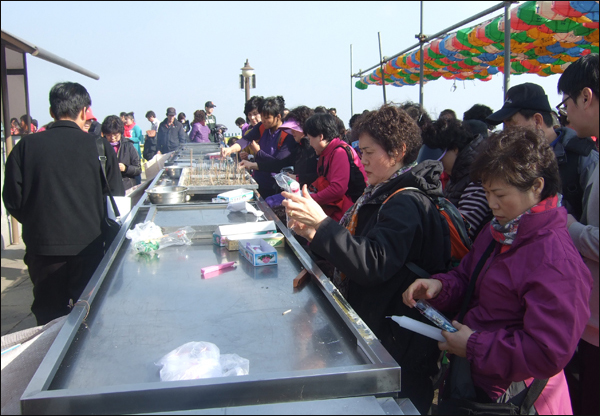 갓바위를 찾은 시민들이 향과 초를 피우며 기도 준비를 하고 있다 / 사진. 평화뉴스 박광일 기자