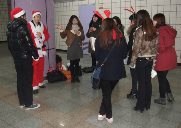 산타 분장을 한 김태혁(23)씨와 요정들이 가정방문에 앞서 지하철역에서 연습을 하고있다.  / 사진. 평화뉴스 박광일 기자