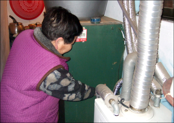 대구시 중구 동인동에 사는 한 할머니가 기름보일러에 찬 기름을 확인하고 있다(2011.1.17) 할머니는 "21만원 하던 게 24만원으로 올랐다"고 말했다 / 사진. 평화뉴스 박광일 기자