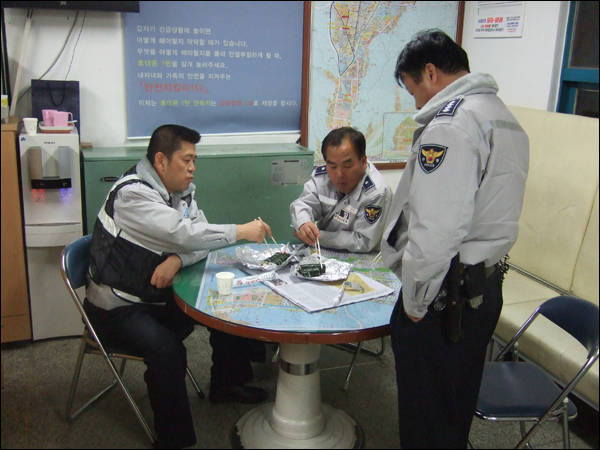 순찰을 마치고 지구대로 돌아와 김밥을 먹는 경찰관들. 한 주민이 야간에 수고한다며 전해주고 갔다고 한다 / 사진. 평화뉴스 박광일 기자