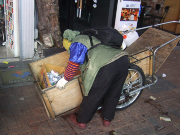 3월 2일 새벽 정모(67) 할머니가 동성로에서 모은 폐지와 깡통을 리어카 안에서 분류하고 있다. 이날 할머니가 밤새 모은 재활용품은 리어카 네 대 분량이지만 2만원어치 밖에 되지 않는다 / 사진. 평화뉴스 박광일 기자