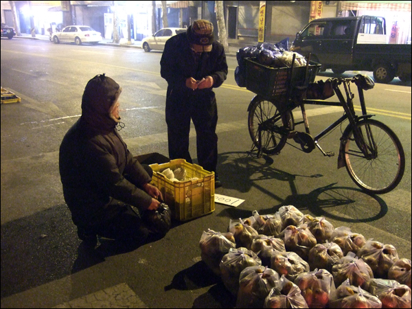 20년째 반짝시장에서 과일을 팔아온 조은규(63)씨가 자전거를 타고 온 손님에게 과일을 팔고 있다 / 사진. 평화뉴스 박광일 기자