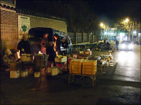 3월 9일 찾은 달성공원 반짝시장. 매일 새벽 5시부터 아침 9시까지 이곳에 장이 선다. 이른 새벽 장사준비를 마친 상인들이 모닥불 옆에서 몸을 녹이며 담소를 나누고 있다 / 사진. 평화뉴스 박광일 기자