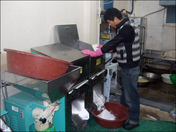 새벽 5시쯤 남편 신종현(32)씨가 전날 밤 불려놓은 쌀을 맷돌기에 넣어 곱게 빻고 있다 / 사진. 평화뉴스 박광일 기자