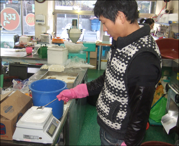 남편 신종현씨가 저울을 이용해 반죽에 넣을 소금을 정확히 계량하고 있다 / 사진. 평화뉴스 박광일 기자