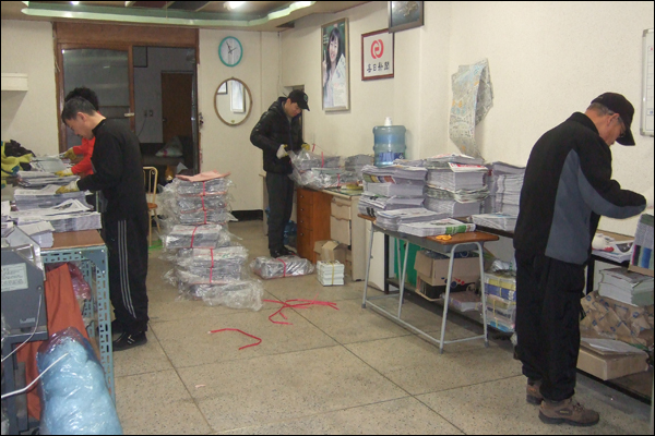 새벽 신문보급소의 풍경. 새벽 12시30분부터 차례로 들어오는 신문에 전단지와 속지를 끼워 넣은 뒤 각 동마다 배달할 신문을 분류하고 배달에 나선다 / 사진. 평화뉴스 박광일 기자