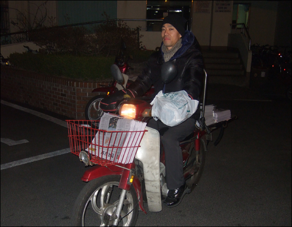 배달할 신문을 오토바이에 싣고 다음 아파트로 이동하는 김창호씨 / 사진. 평화뉴스 박광일 기자