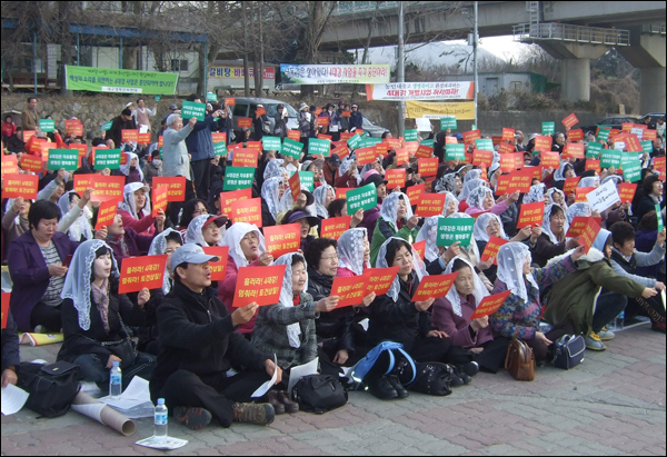 '4대강 되찾기' 전국 미사에 참석한 참가자들이 빨간색과 초록색의 플랫카드를 들고 "흘러라! 4대강! 멈춰라 토건삽질!", "4대강은 자유롭게! 생명은 평화롭게!" 구호를 외치고 있다 / 사진. 평화뉴스 박광일 기자