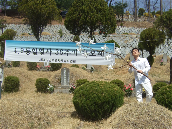 지역 민족예술인 이상옥씨가 바람개비가 달린 나뭇가지를 들고 묘지 주변을 돌며 희생자들의 넋을 기리는 진혼 퍼포먼스를 진행했다 / 사진. 평화뉴스 박광일 기자