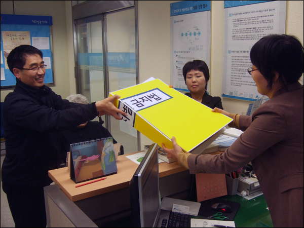 장애인단체 회원들이 '2011 대구국제마라톤대회' 참가 거부 사례를 비롯한 56건의 장애인 차별 관련 내용이 담긴 진정서를 국가인권위 대구사무소에 제출하고 있다 / 사진. 평화뉴스 박광일 기자