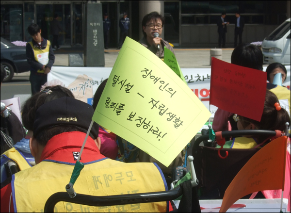 집회에 참석한 한 장애인의 휠체어에 꽂혀있는 깃발. "장애인의 탈시설-자립생활권리를 보장하라"고 적혀있다 / 사진. 평화뉴스 박광일 기자
