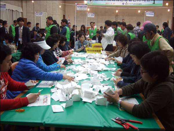 개함부 탁자 위에 놓인 투표용지를 개표사무원들이 각 후보자 별로 분류하고 있다 / 사진. 평화뉴스 박광일 기자