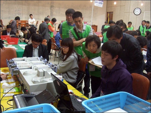 투표지분류기 앞에서 각 후보자 측 참관인들이 개표결과를 유심히 지켜보고 있다 / 사진. 평화뉴스 박광일 기자