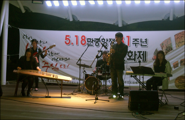 크로스오버 밴드 '씨밀레'가 전통악기 가야금과 신디사이저, 베이스기타, 드럼, 색소폰을 비롯한 서양악기가 한데 어우러진 연주를 선보이고 있다. '렛 잇 비', '플라이 미 투 더 문', '오버 더 레인보우'를 비롯한 팝송과 '너영나영'을 비롯한 민요를 노래해 공원 주변에 있던 시민들의 관심을 끌기도 했다 / 사진. 평화뉴스 박광일 기자