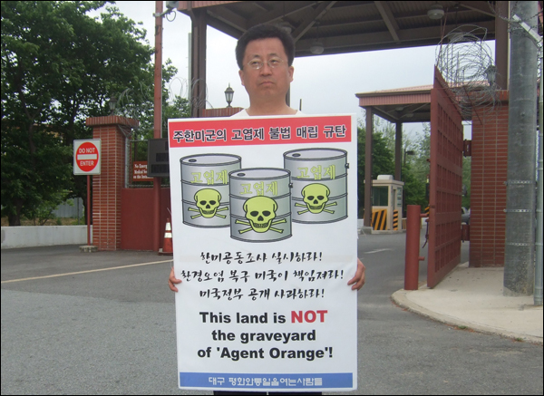 대구평화와통일을여는사람들 백창욱 목사가 왜관 캠프 케럴 미군기지 정문 앞에서 "한미공동조사 실시하라, 환경오염 복구 미국이 책임져라, 미국정부 공개사과 하라"는 문구가 적힌 피켓을 들고 1인 시위를 하고 있다 (2011.05.20) / 사진. 평화뉴스 박광일 기자