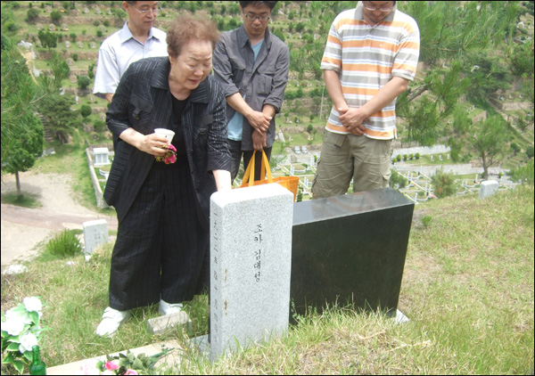 일본군 위안부 피해자 이용수(83) 할머니가 먼저 세상을 떠난 김분순(1922.10~2005.1) 할머니의 묘비를 쓰다듬으며 눈물을 흘리고 있다 (2011.06.06) / 사진. 평화뉴스 박광일 기자