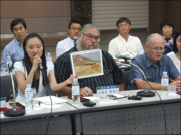 스티브 하우스씨가 직접 찍은 사진을 들고 설명한 말을 통역인이 전달하고 있다 (2011.07.27) / 사진. 평화뉴스 박광일 기자
