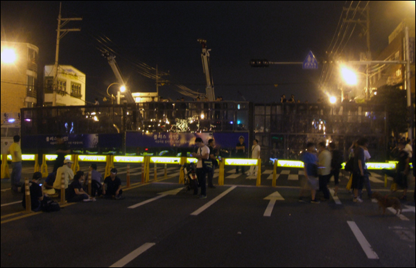 경찰이 부산 영도구 봉래로타리에 설치한 차벽. '3차 희망버스' 참가자들과 주민들이 차벽 주위를 살펴보고 있다 (2011.07.30) / 사진. 평화뉴스 박광일 기자
