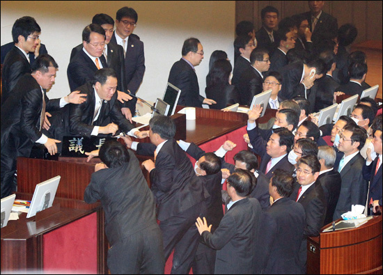 22일 오후 서울 여의도 국회 본회의장에서 여당의 한미FTA 비준안 날치기 강행처리를 저지하기 위해 발언대에 올라간 민주당 민주노동당 의원들이 항의하는 가운데 의장석에 앉아 있던 정의화 국회부의장 앞 민주당 최규성 의원과 민주노동당 김선동 의원이 의사봉을 빼앗으려 하고 있다.ⓒ김철수 기자
