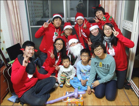 "메리크리스마스"라며 활짝 웃는 산타들과 제성이 가족 / 사진. 평화뉴스 김영화 수습기자