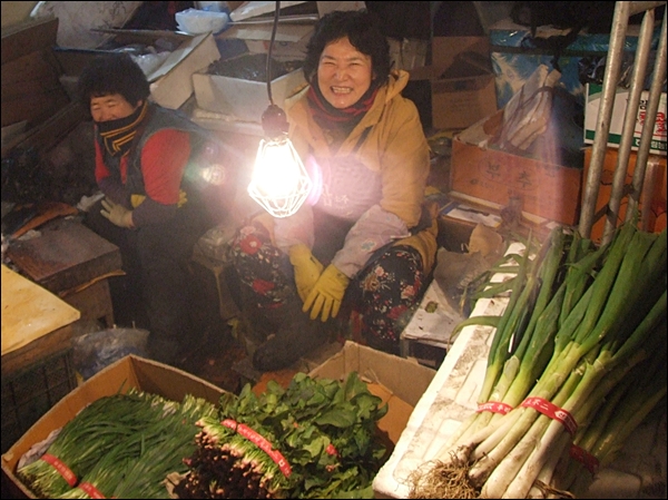 건어물 상가 주변에서 야채를 파는 김이쁜 할머니가 환하게 웃고 있다(2012.1.17) / 사진. 평화뉴스 김영화 수습기자