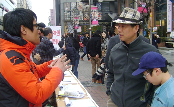 시민에게 한미FTA에 대해 설명하고 있는 최무윤(34)씨(2012.2.25) / 사진.평화뉴스 김영화 수습기자