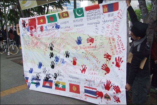 이날 행사에서 이주노동자들은 모국 국기에 하고싶은 말을 쓰고 손도장을 찍었다(2012.4.29) / 사진.평화뉴스 김영화 기자