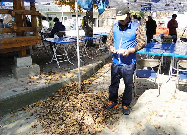박명석 이장이 고사한 느티나무 잎 더미를 발로 모으고 있다(2012.10.7) / 사진. 평화뉴스 김영화 기자
