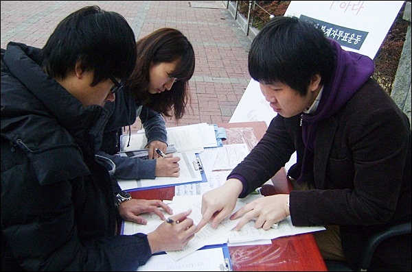 대학생 부재자 신청자를 돕는 대구참여연대 이승호 간사(2012.3.19 경북대) / 사진.평화뉴스 김영화 기자
