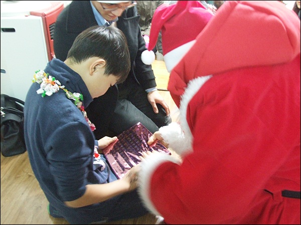 선물을 뜯어보는 민성이(2012.12.24) / 사진. 평화뉴스 김영화 기자