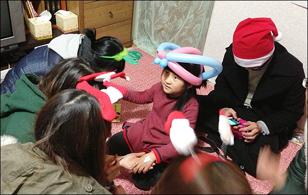 풍선 왕관을 쓰고 페이스페인팅을 받는 지연이(2012.12.24) / 사진. 평화뉴스 김영화 기자
