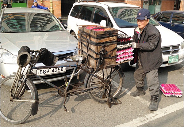 자전거에서 계란 2판을 내리는 할아버지(2013.1.31) / 사진. 평화뉴스 김영화 기자