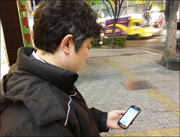 명덕네거리에서 스마트폰을 쳐다보며 '콜'을 기다리는 박모씨 / 사진. 평화뉴스 김영화 기자