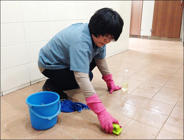 9년째 대구가톨릭대 '환경미화원'으로 일하고 있는 김미숙(59)가 화장실 타일 때를 벗기고 있다(2013.4.18)