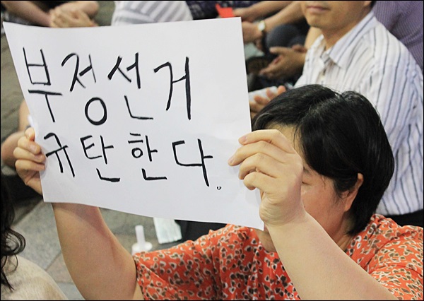 '부정선거 규탄한다'고 적힌 피켓을 든 시민(2013.6.28.동성로) / 사진. 평화뉴스 김영화 기자