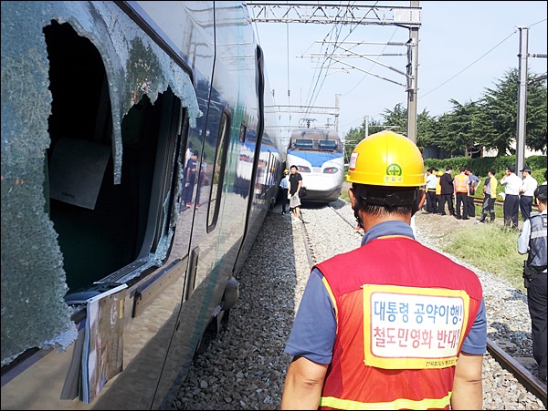 지난 31일 오전 8시 대구역 열차충돌 사고 현장...깨진 KTX 열차 창문 앞에서 '대통령 공약이행 철도민영화 반대' 조끼를 입고 있고 복구 작업에 들어간 철도노조 조합원 / 사진. 김동은