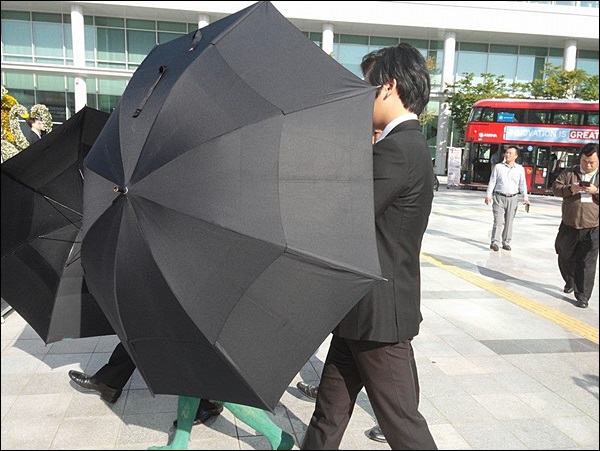 우산으로 이상옥씨를 둘러싼 경호원들 / 사진 제공. 인권운동연대