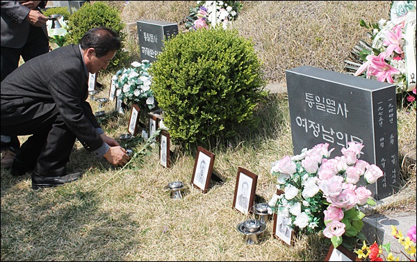 인혁당 사건으로 당시 목숨을 잃은 희생자들과 이미 돌아가신 피해자 등 모두 17명의 영정사진이 묘소 앞에 놓여 있다(2014.4.9.현대공원묘지) / 사진. 평화뉴스 김영화 기자