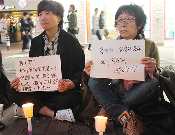 "희망의 끈을  놓지 말아줘"라고 적힌 스케치북을 든 시민(2014.4.18) / 사진. 평화뉴스 김영화 기자