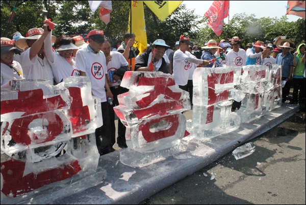 '한중FTA' 얼음조각을 망치로 깨뜨리는 농민들(2014.7.14) / 사진.평화뉴스 김영화 기자